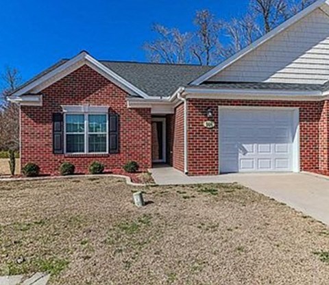 A red brick house with a white garage door.