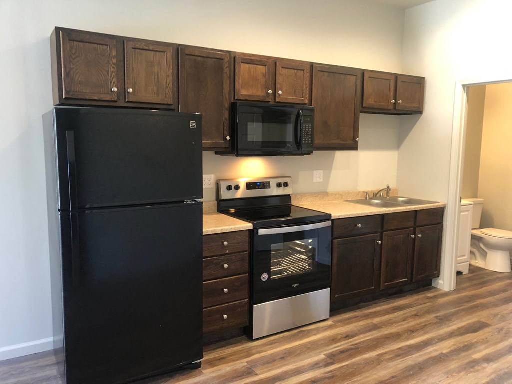 a kitchen with black appliances and wooden cabinets