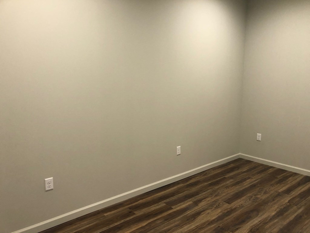 a empty room with white walls and wooden floors