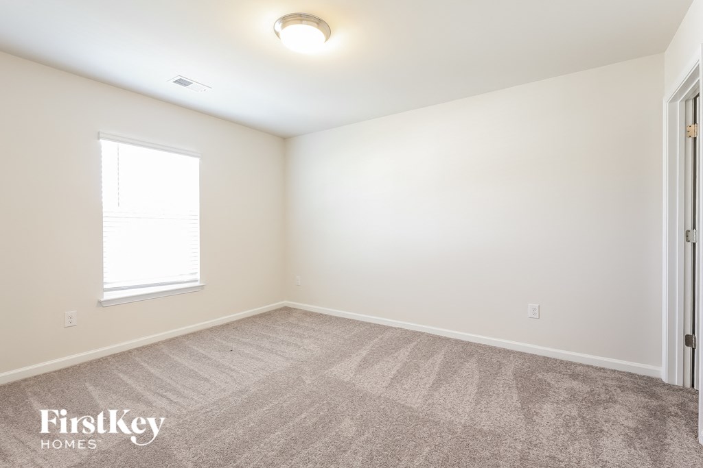 a bedroom with a carpeted floor and a window