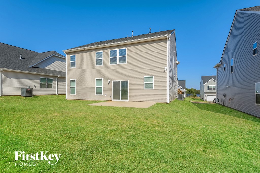 the backyard of a house with a green lawn and a blue sky