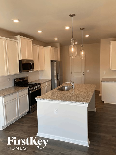 an updated kitchen with white cabinets and granite counter tops