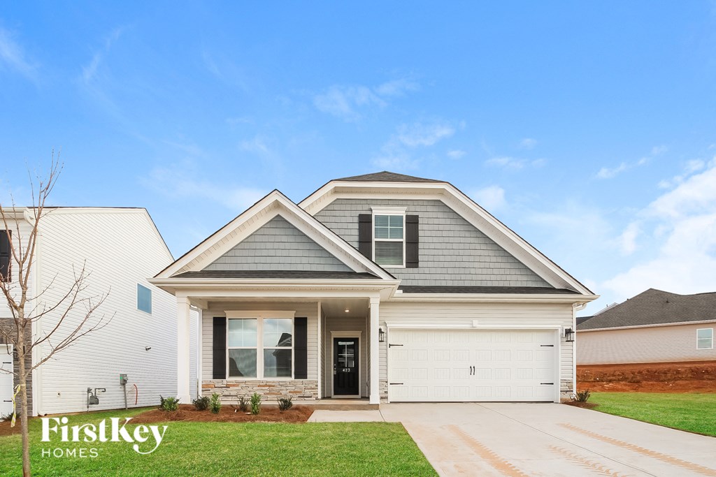 a white house with a gray roof and a lawn