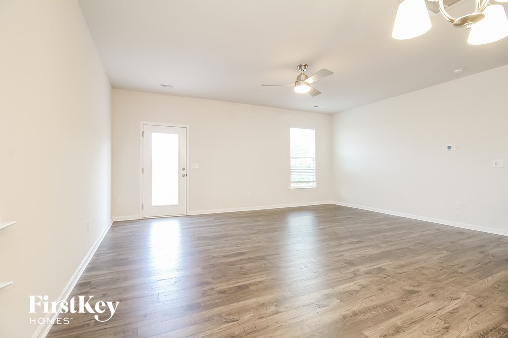 an empty living room with wood floors and white walls