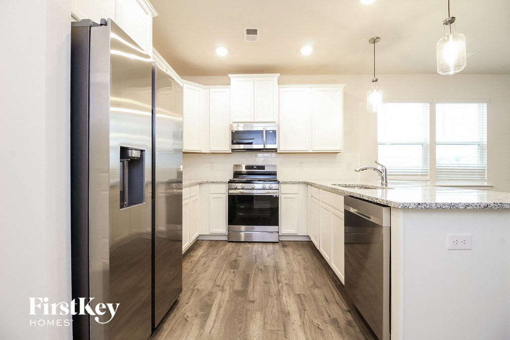 a kitchen with white cabinets and stainless steel appliances