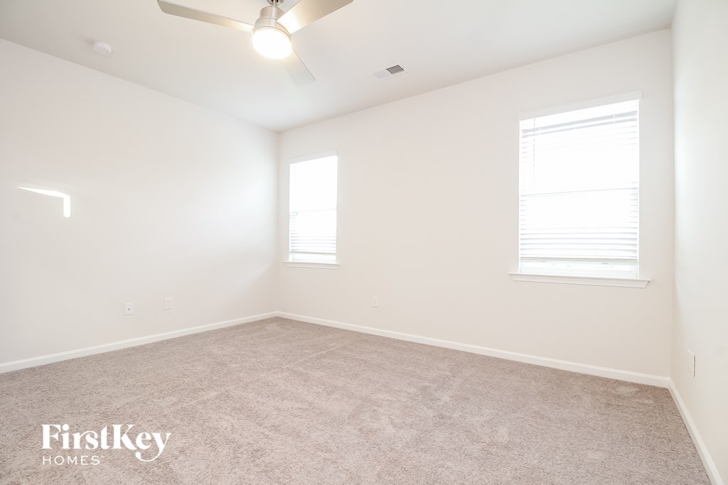 a bedroom with a carpeted floor and two windows