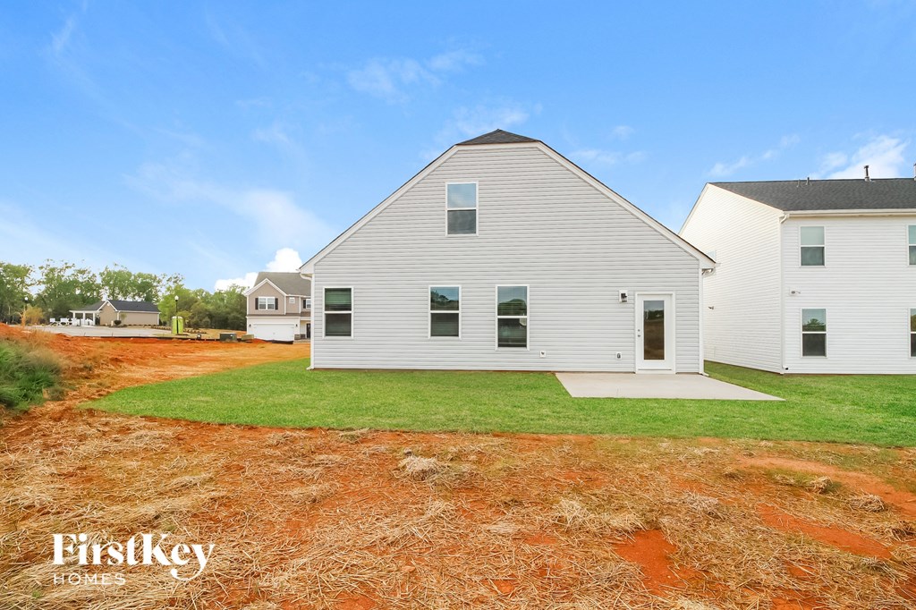 a white house with a yard in front of it and a blue sky