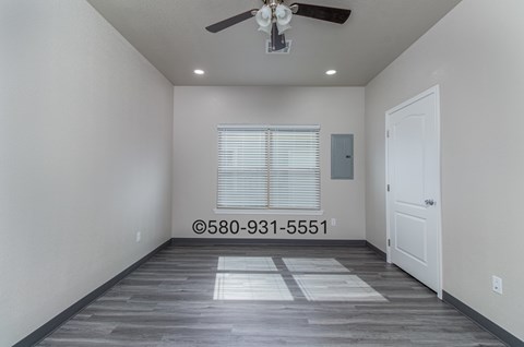 A room with a ceiling fan and a door.
