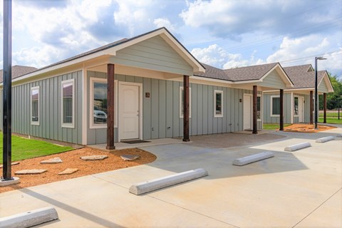 a manufactured home with a porch and a parking lot