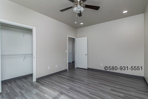A room with a ceiling fan and a door.
