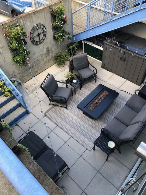 A patio with a couch, chair, and table.