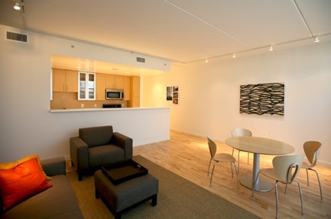 A modern living room with a grey couch and a white table.