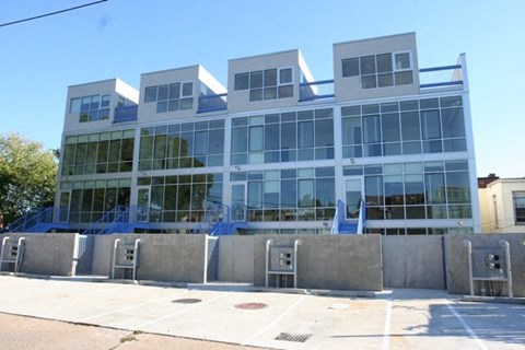 A modern building with a glass facade and a blue sky in the background.