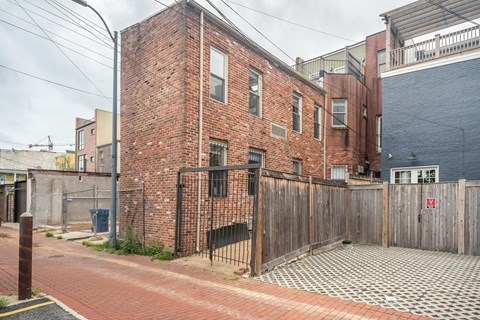 A red brick building with a black gate in front.
