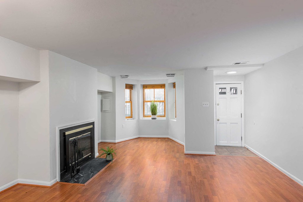 a living room with a fireplace and wooden floors