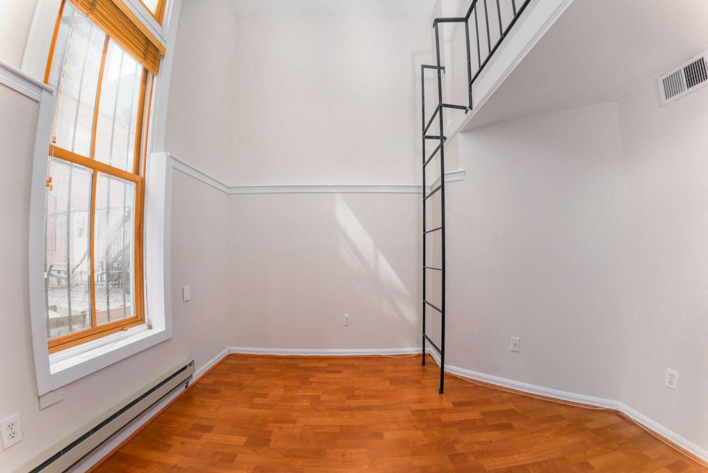 a white room with a spiral staircase in the corner and a window