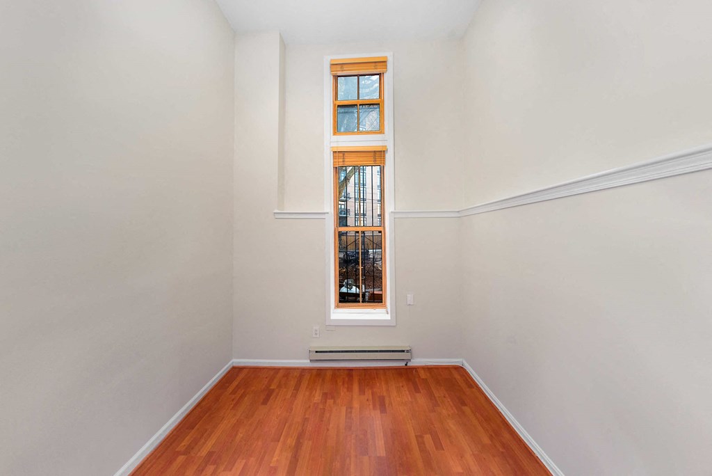 a living room with a window and a wooden floor