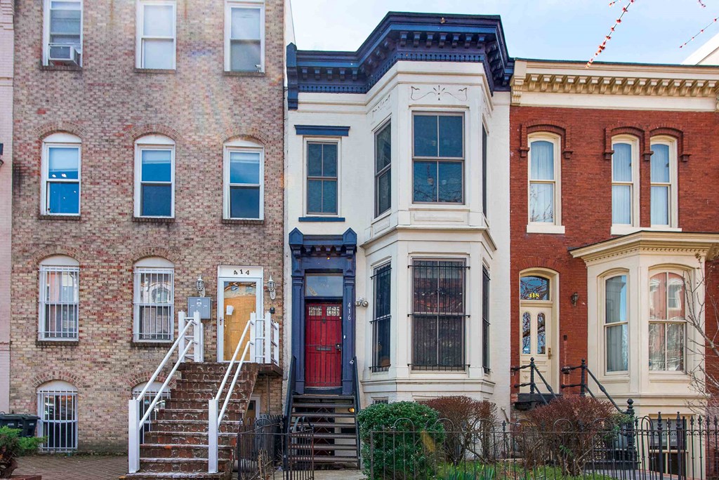 a row of houses on a city street with a red door
