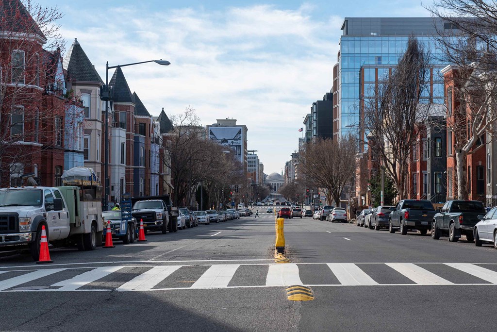 a city street with traffic cones and cars parked on the side of the road