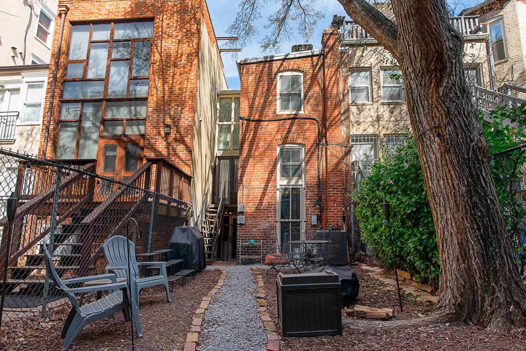 a courtyard with a tree and a brick house