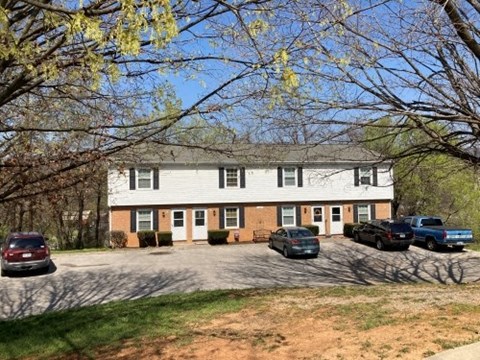 a white house with cars parked in a parking lot