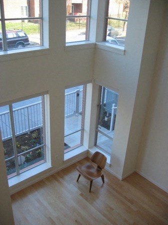 a chair sitting in the corner of a room with windows