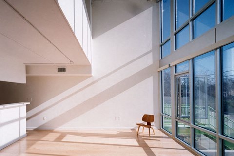 A room with a wooden chair and a window.