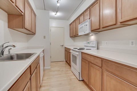 A kitchen with wooden cabinets and a white stove top oven.