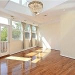 an empty living room with stairs and a chandelier