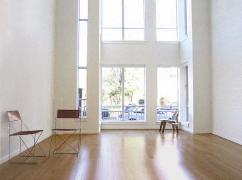 Two chairs sit in a white room with large windows.