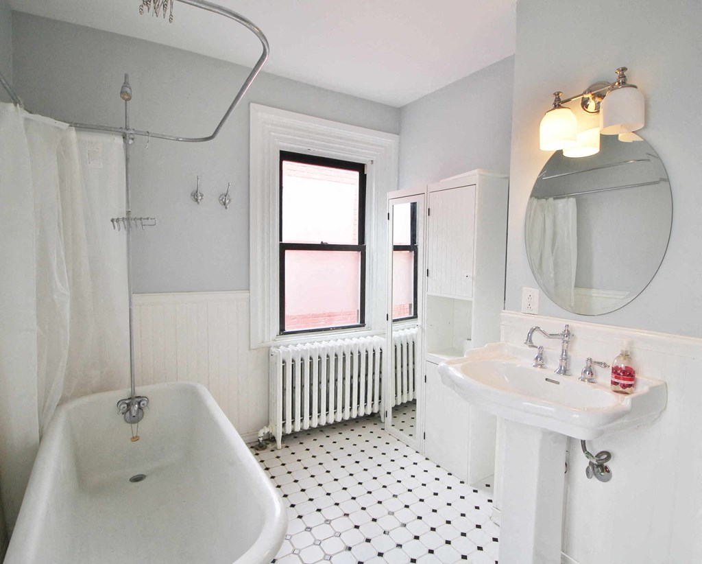 A white bathroom with a black and white floor.