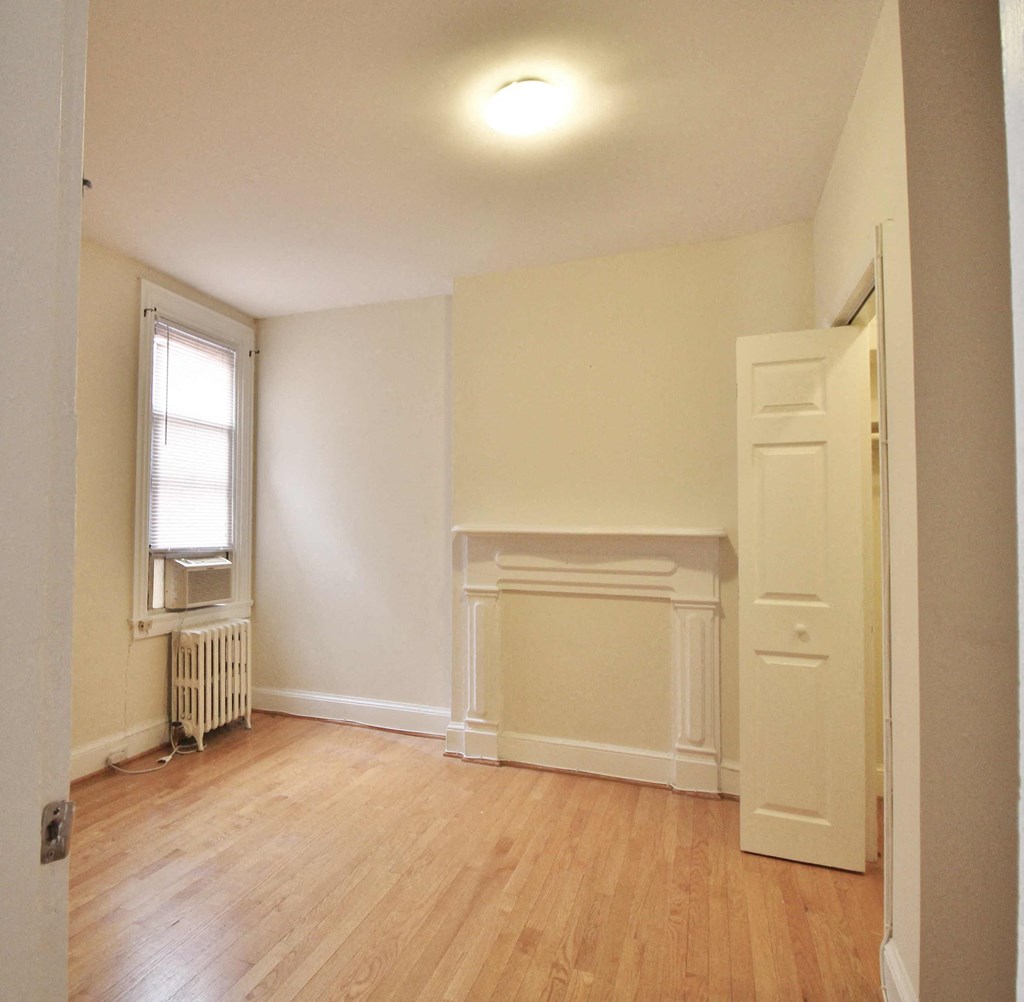 A room with a fireplace and a window.