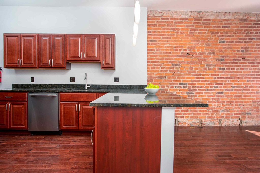 a kitchen with a brick wall and a counter top