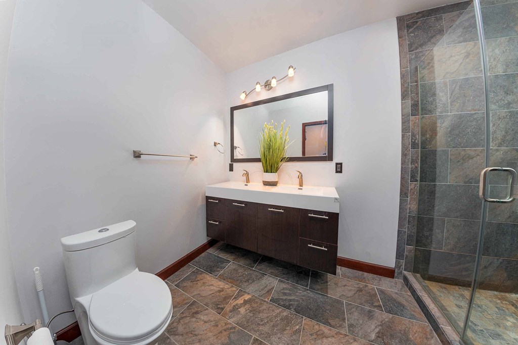 a bathroom with a toilet and a sink and a shower