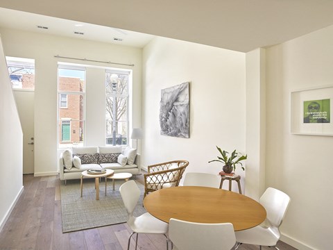 a living room with a table and chairs and a window