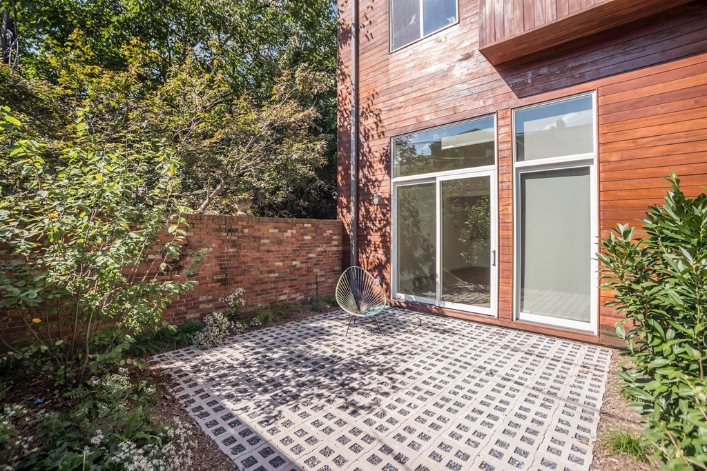 a patio with a brick wall and a sliding glass door