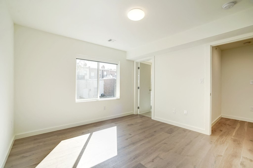 a living room with white walls and a window