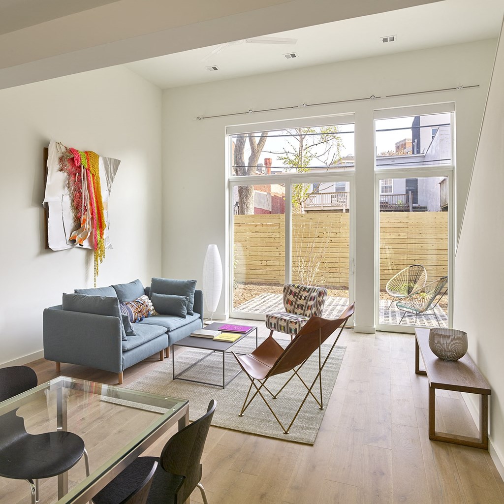 a living room with a couch and chairs and a glass table