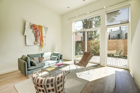 A living room with a grey couch, a chair, a coffee table and a window.