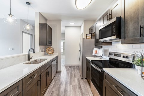 A kitchen with dark wood cabinets and stainless steel appliances.