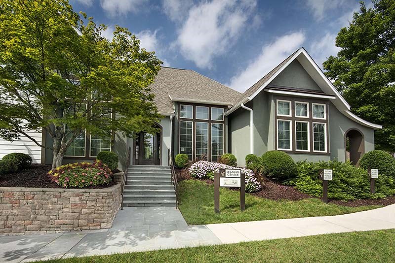 a green house with a sign in front of it