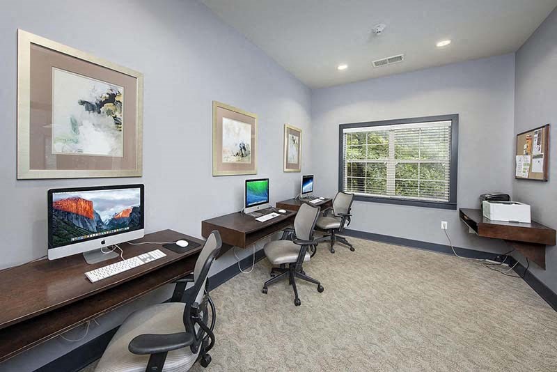 a room with two computer desks and a window