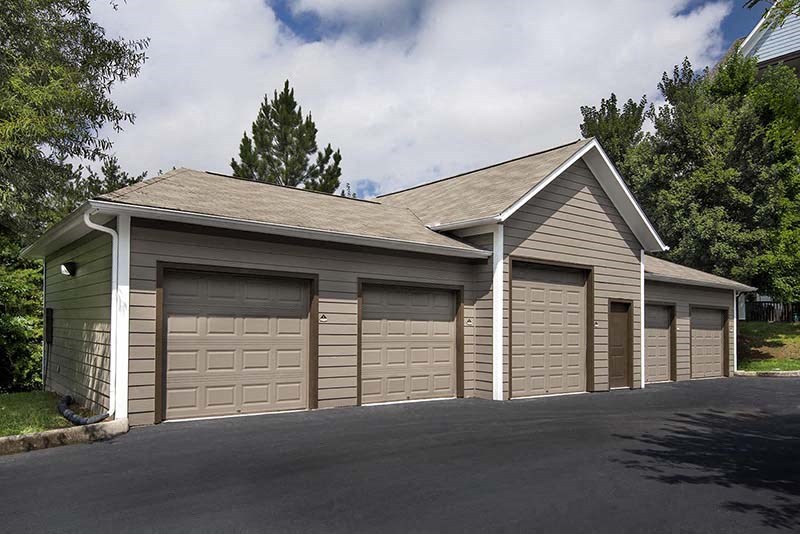 a garage with three garage doors and a parking lot
