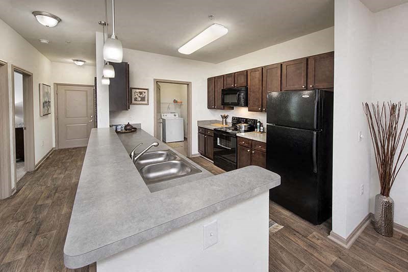a kitchen with a sink and a black refrigerator