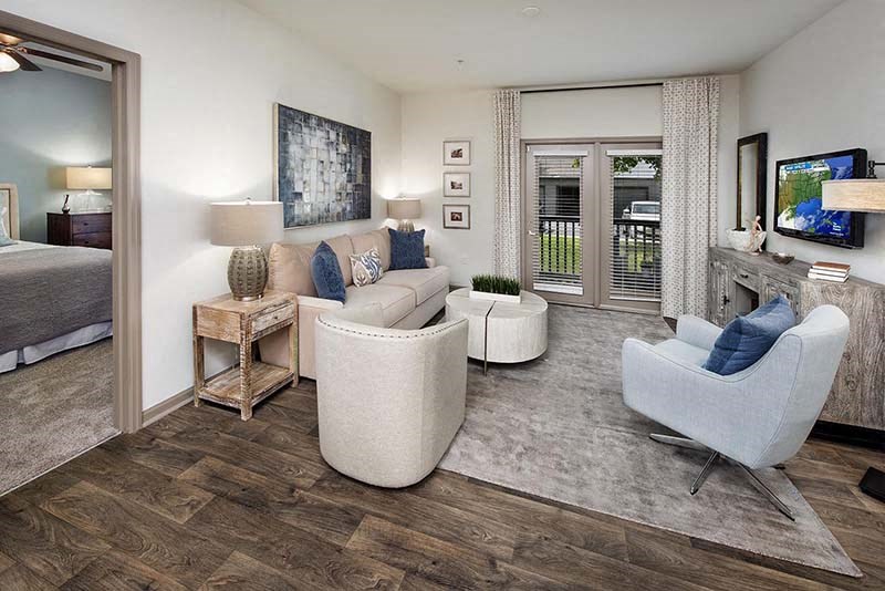 a living room with a couch and chairs and a tv