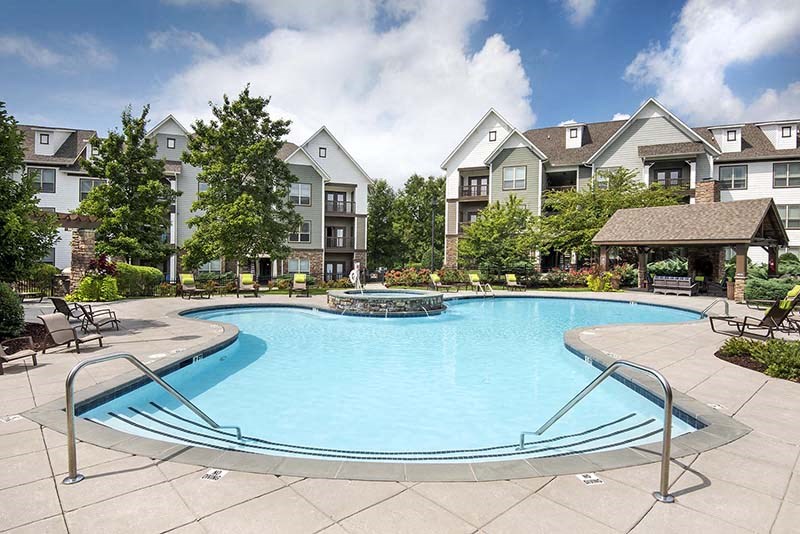 a large swimming pool in front of an apartment building