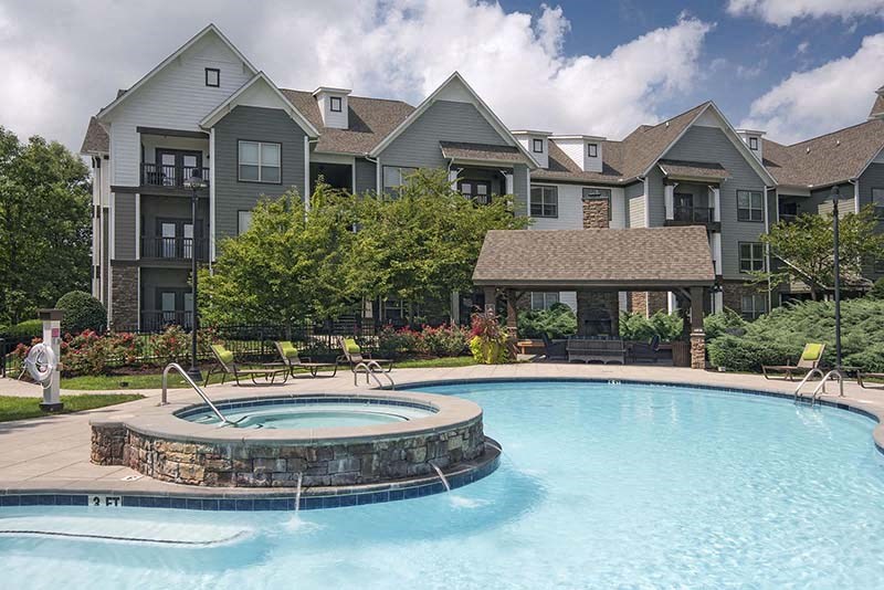 a large swimming pool with a house in the background