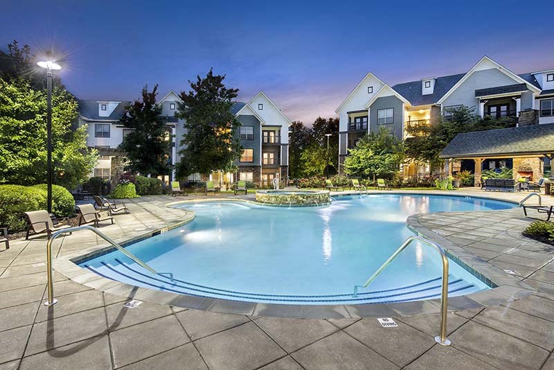 a swimming pool with an apartment building in the background