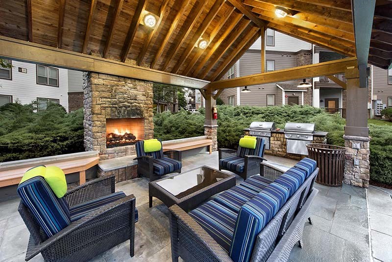 a covered patio with furniture and a fireplace