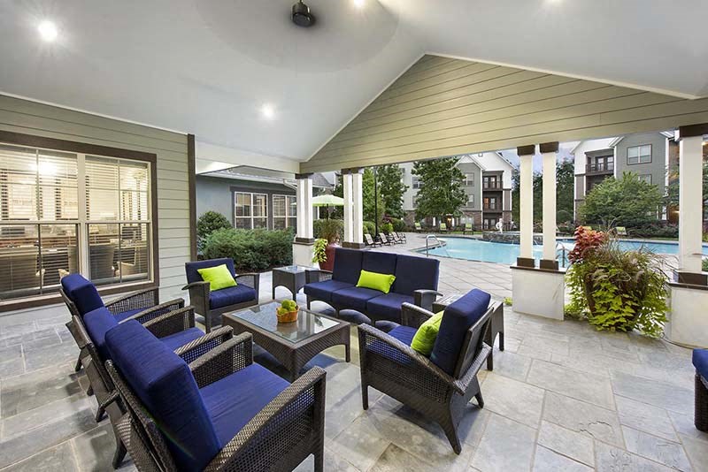 a large patio with blue furniture and a pool